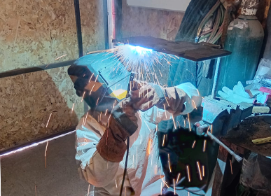 Alumno realizando práctica de soldadura en taller de INDESOLD.
